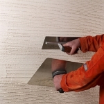 Image of a person holding a trowel in each hand, applying the K Rend UF Fibre Base product.